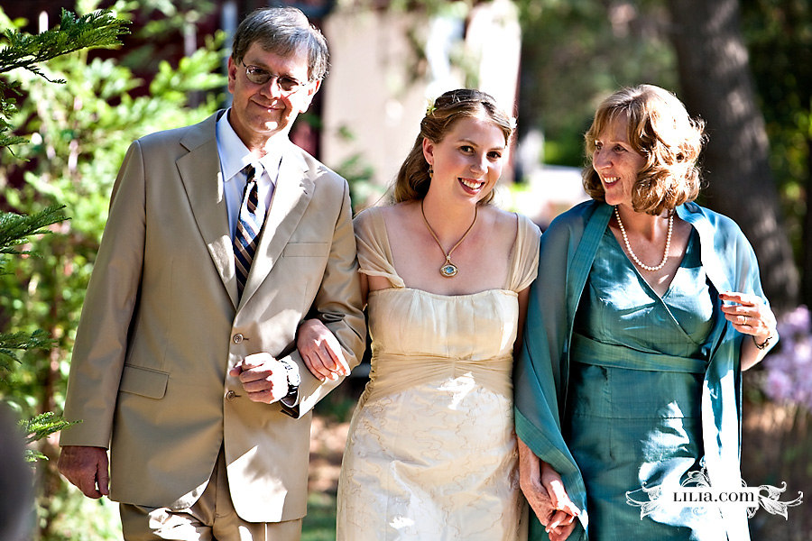 Bride walking down aisle with mom and dad